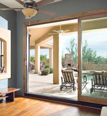 An open sliding glass door leading to a backyard