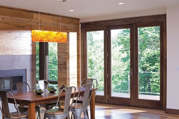 patio doors leading to porch overlooking wooded backyard