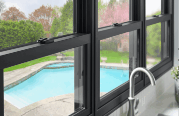 Dark composite window frame looking out onto a backyard patio and swimming pool
